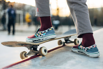 Skateboarder in sneakers riding on board in outdoor park