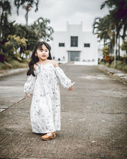 Cute smiling girl standing on footpath