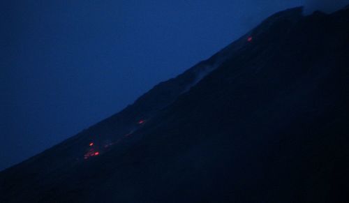 Silhouette mountain against blue sky at night