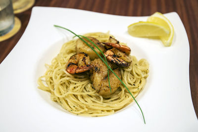 Close-up of spaghetti with prawns served in plate on table