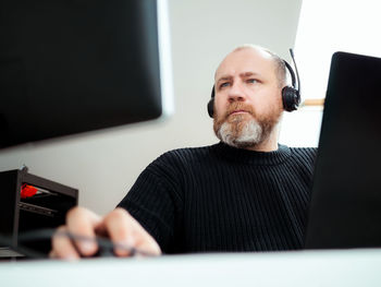 Portrait of young man using laptop at home