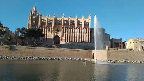 Exterior of building by river against clear sky