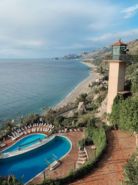 High angle view of swimming pool by sea against sky