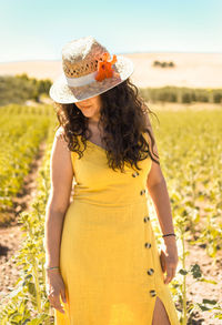 Woman wearing hat standing on field