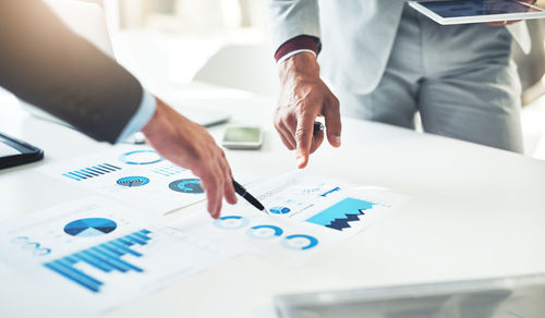 Midsection of business colleagues working on table