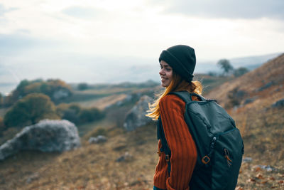 Young woman wearing hat standing against sky