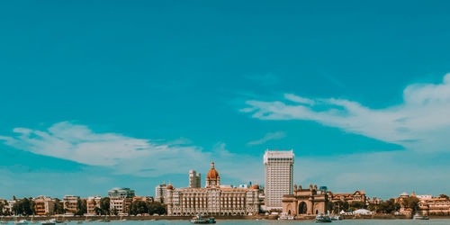 Buildings in city against blue sky