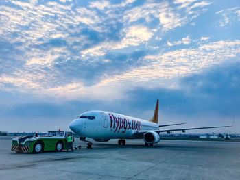 Airplane on airport runway against sky