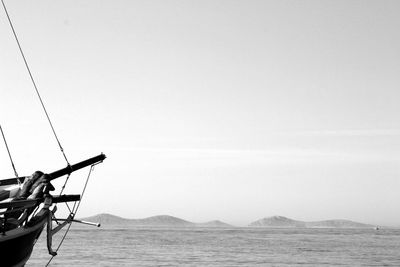 Boat moored on sea against clear sky