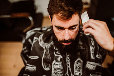 Cropped hands of barber grooming customer in salon