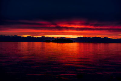 Scenic view of sea against dramatic sky during sunset