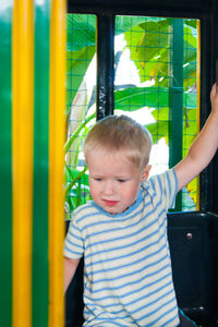 Close-up of cut boys standing in amusement park