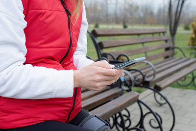 Woman wearing sport clothes and knee brace or orthosis after leg surgery, walking in 