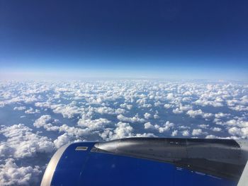 Cropped image of airplane above clouds