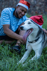 Man with his pet with christmas hats.