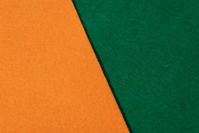 Close up orange and green felt texture. textured fabric backdrop. color of the year 2023