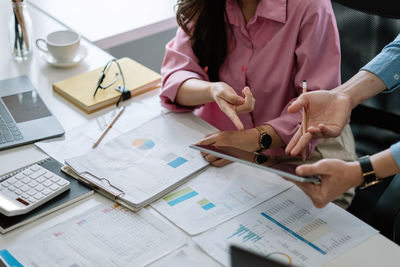 Midsection of business people working at desk in office