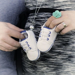 Cropped image of couple holding baby booties
