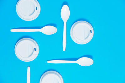 Set of plastic cutlery neatly arranged on a blue background