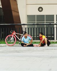 Men sitting on road in city