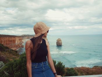 Woman wearing hat against sea against sky