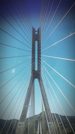 Low angle view of suspension bridge against blue sky