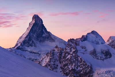 Scenic view of snowcapped mountains against sky during sunset
