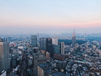 High angle view of modern buildings in city against sky during sunset