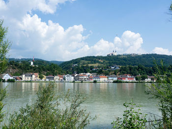 Scenic view of lake by buildings against sky
