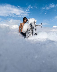 Man riding motorcycle on snow against sky