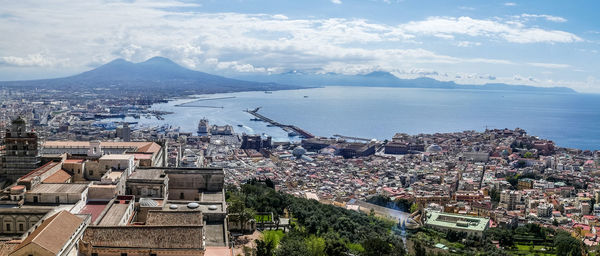 High angle view of townscape by sea against sky