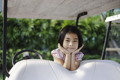 Portrait of smiling girl on golf cart