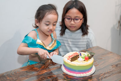 Girl cutting cake at home