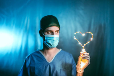 Portrait of man holding heart shape