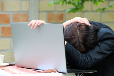 Midsection of man using mobile phone while sitting on table
