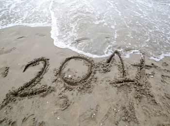 Big text 2017 on the sand of the sea waiting to be canceled by the wave of the sea