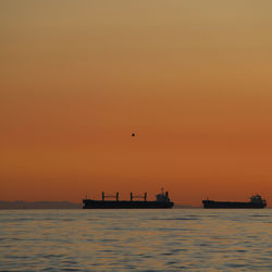 Boat sailing in sea at sunset