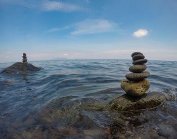 Stack of pebbles on beach against sky