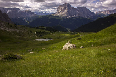 Scenic view of field and mountains against sky in dolomites 