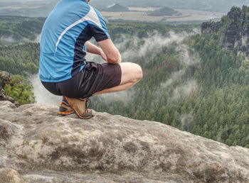 Hiker legs hiking in fall nature enjoy view. feets in trekking shoes and legs short running trousers