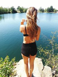 Rear view of young woman standing in lake