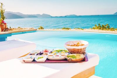 High angle view of food served on table at poolside against sea