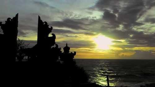 Silhouette statue against sky during sunset