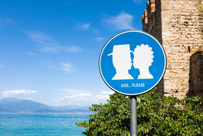 Low angle view of road sign against blue sky