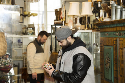 Man checking trinket in antique shop