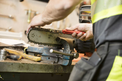 Man working on chainsaw in workshop