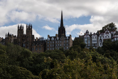 Buildings in city against cloudy sky