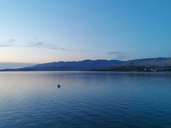 Scenic view of sea and mountains against sky