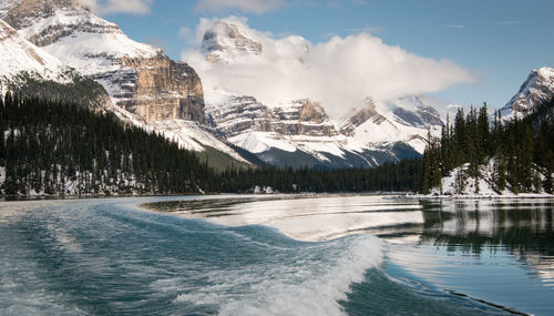 Panoramic view of lake by snowcapped mountains against sky