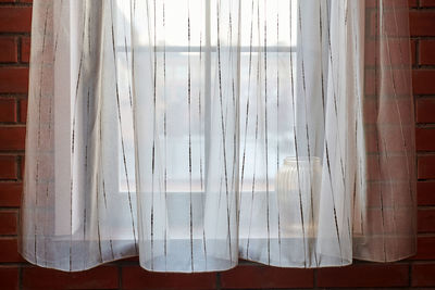 Close-up of curtain against window at home